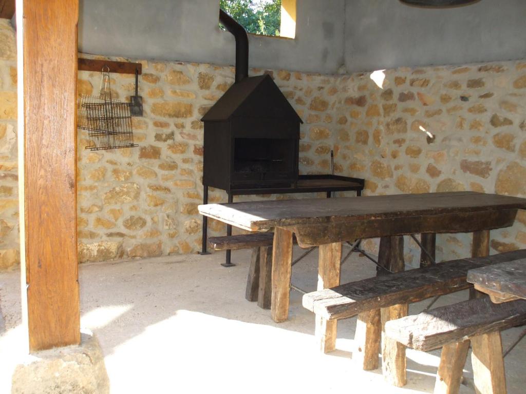 Habitación con mesa de madera y estufa de leña. en Apartamentos La Corraliza, en Totero