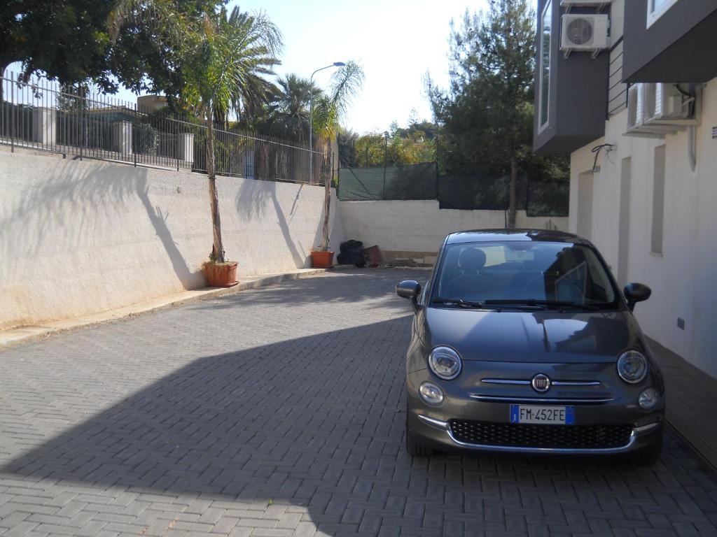 a small car parked on the side of a street at Summer Beach Rooms in Fontane Bianche