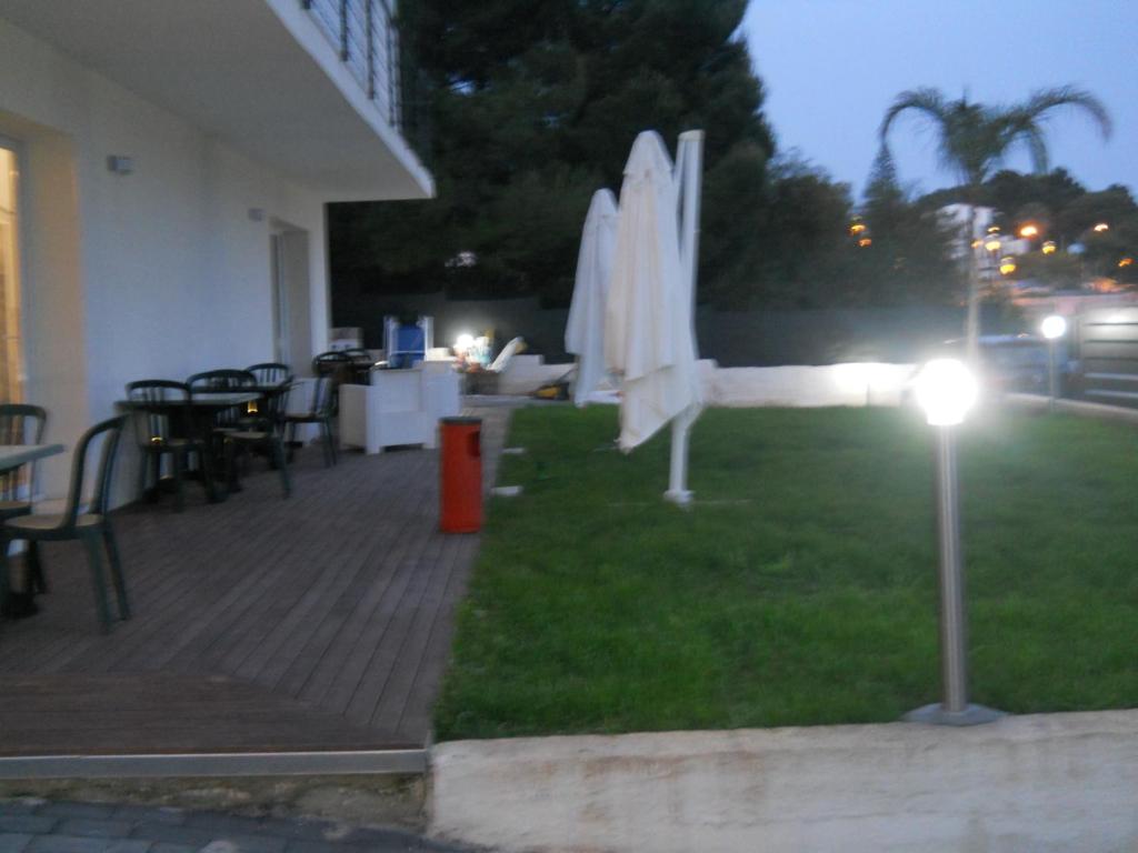 a street light with an umbrella and tables and chairs at Summer Beach Rooms in Fontane Bianche