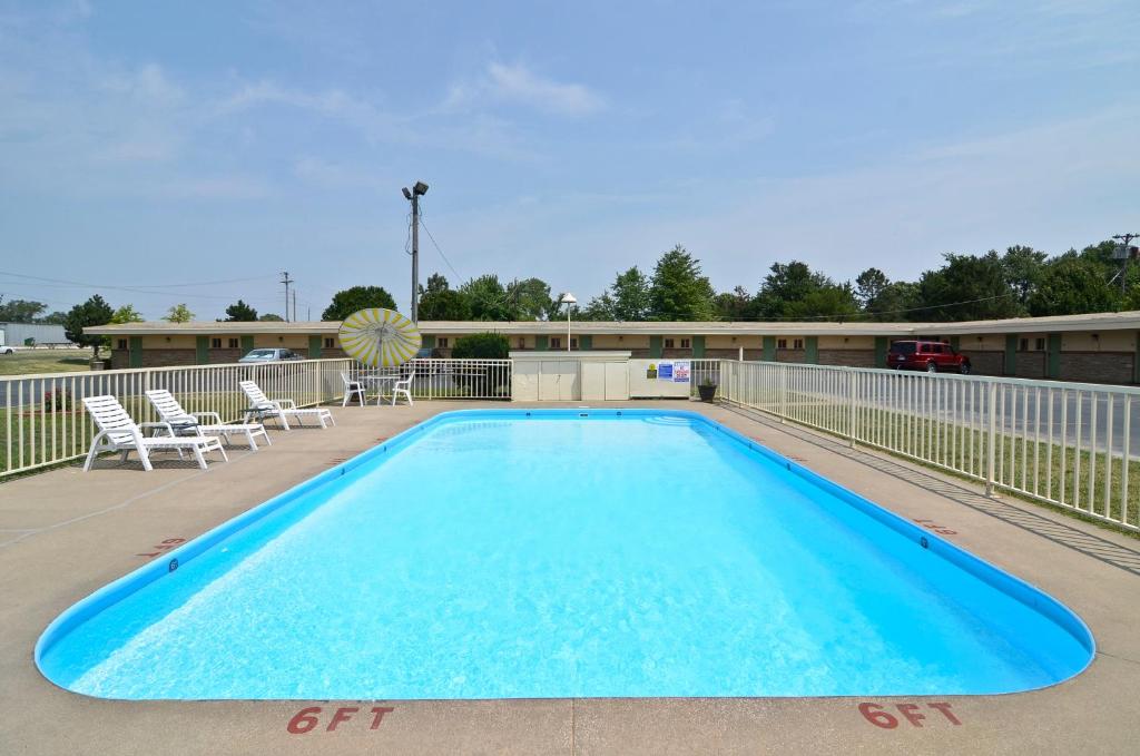 una piscina con sillas y una valla en Americas Best Value Inn Iola, en Iola