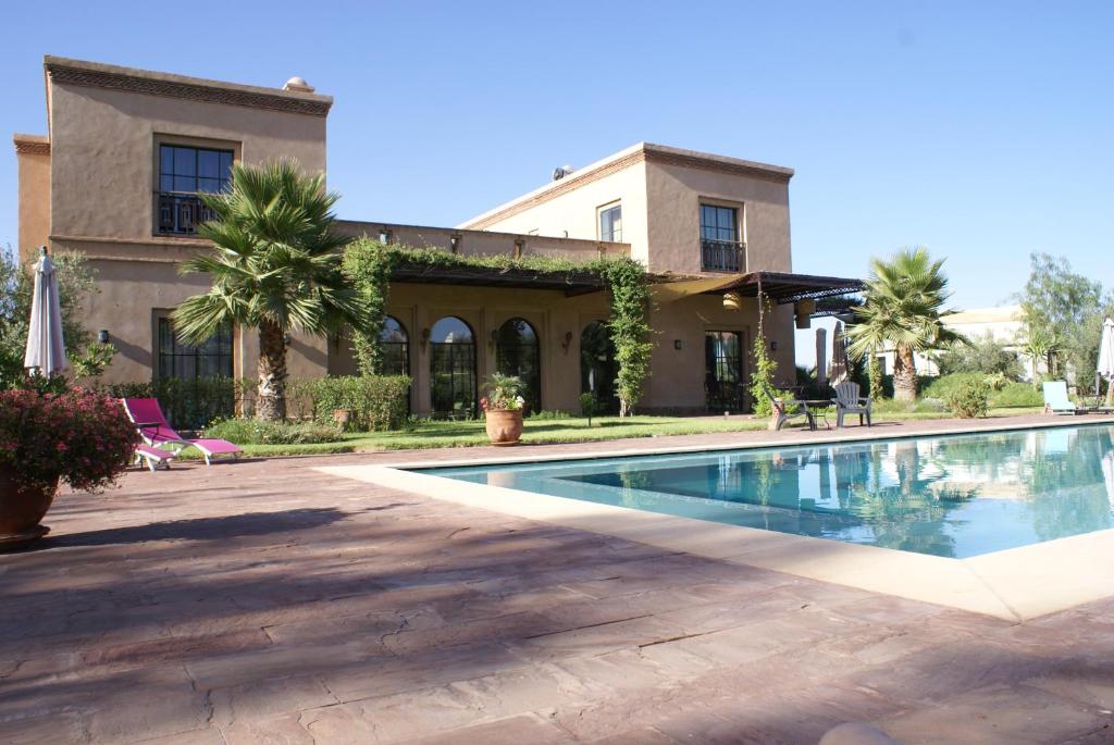 a house with a swimming pool in front of a building at La Kasbah Aalma D'or in Najem