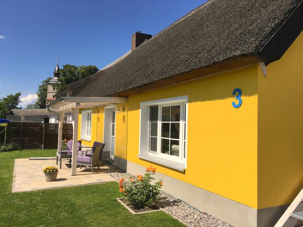 ein gelbes Haus mit schwarzem Dach in der Unterkunft "Jugendliebe" in Benz auf Usedom in Benz