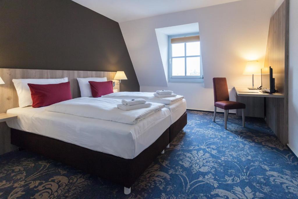 En eller flere senger på et rom på martas Hotel Lutherstadt Wittenberg