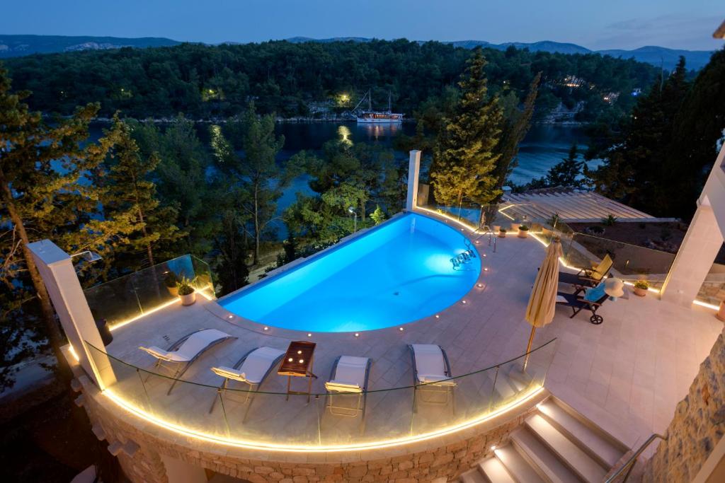 - une piscine dans un complexe la nuit dans l'établissement Luxury Villa Hvar Enigma with Pool, à Vrboska