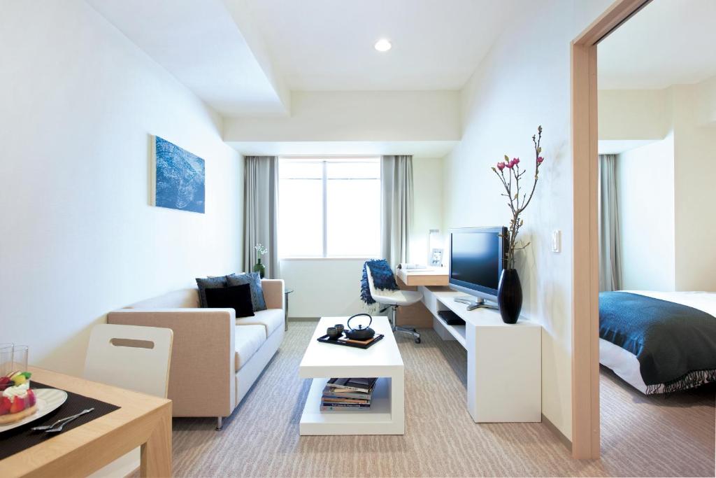 a hotel room with two beds and a television at Fraser Residence Nankai Osaka in Osaka