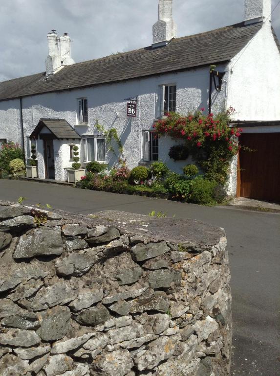 a stone wall in front of a white building at Low Fell in Ulverston