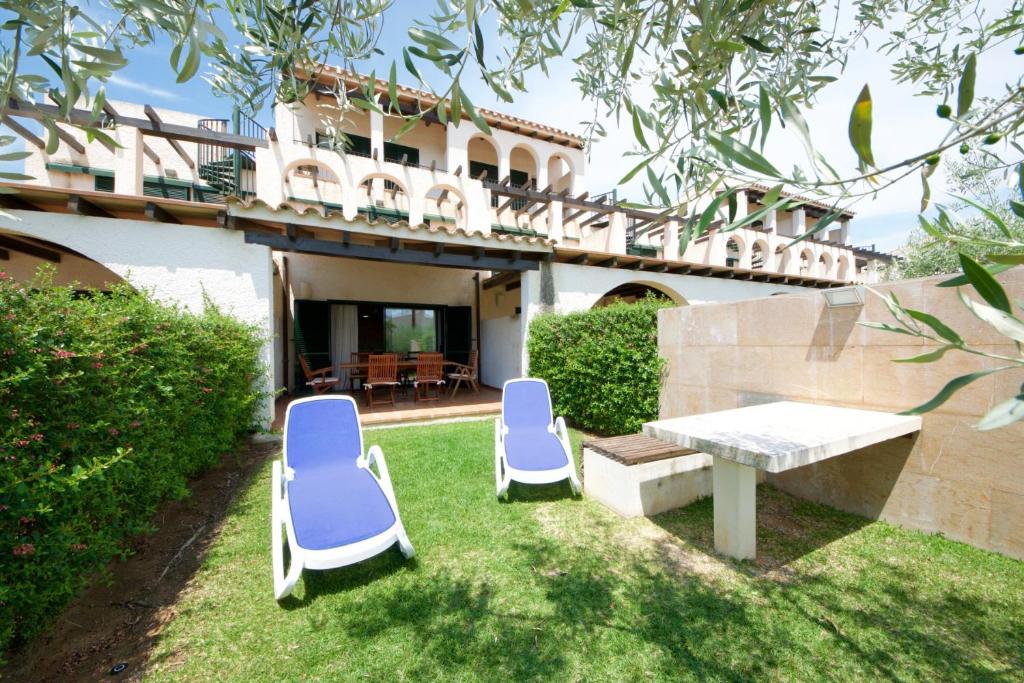 two blue chairs and a table in a yard at Lirio in L'Ampolla