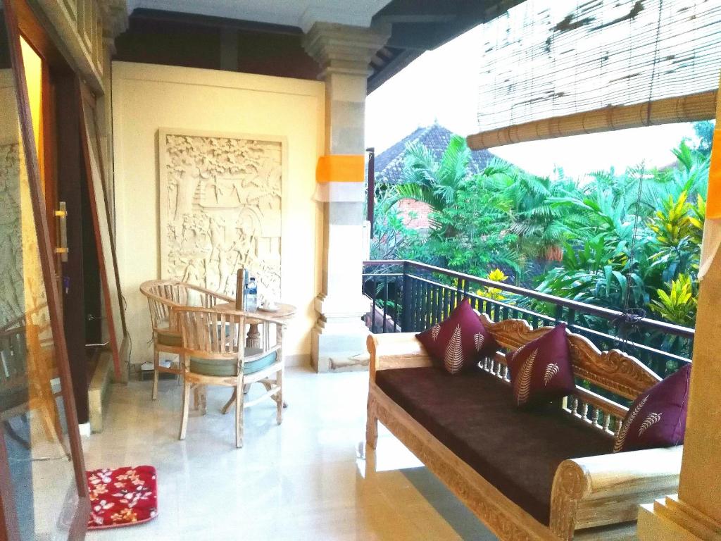 - un salon avec un canapé et une grande fenêtre dans l'établissement Qiul Guest House, à Ubud