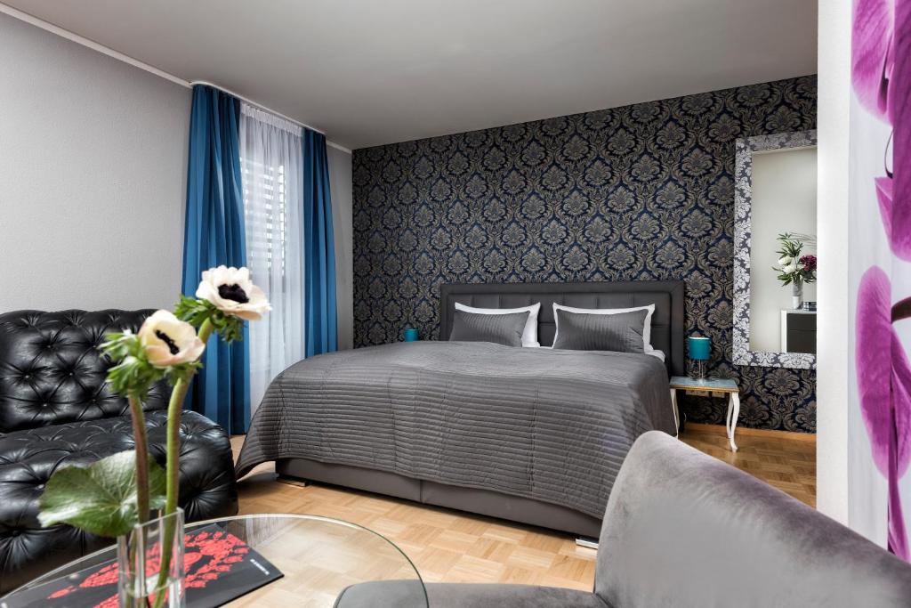 a bedroom with a bed and a couch at Hotel Ambassador-Berlin Grünau in Berlin