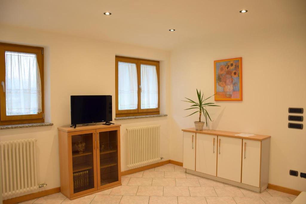a living room with a tv on top of a cabinet at Chiara in Roncegno