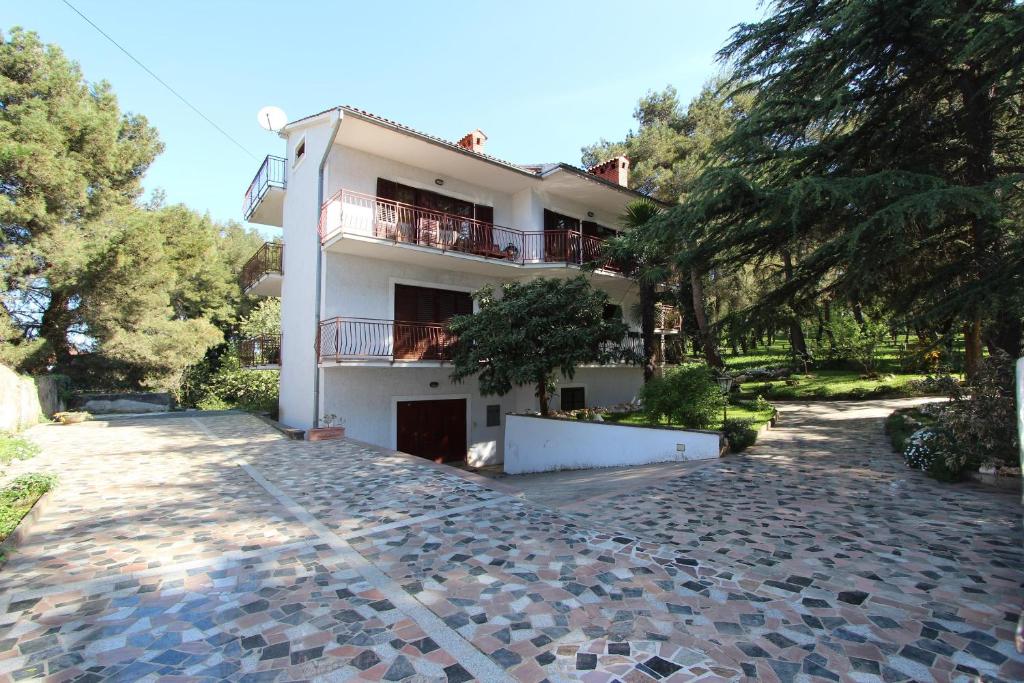 a large white building with a cobblestone driveway at Apartment Clementina in Višnjan