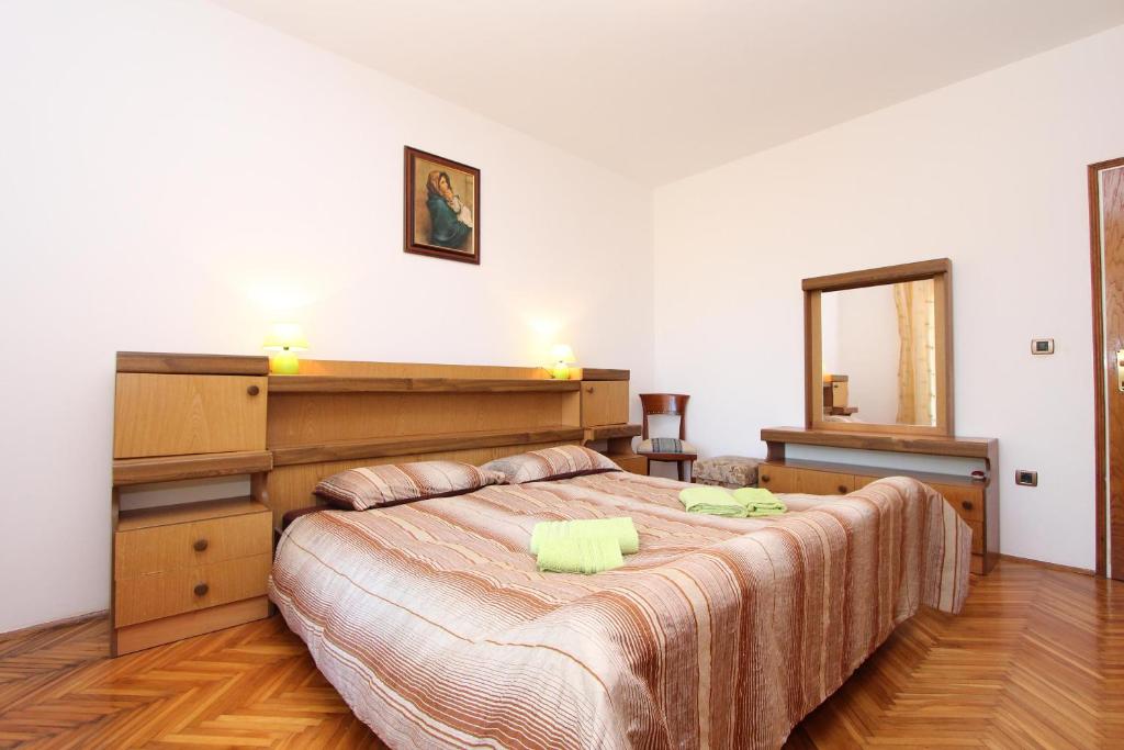 sypialnia z dużym łóżkiem i lustrem w obiekcie Apartment Clementina w mieście Višnjan