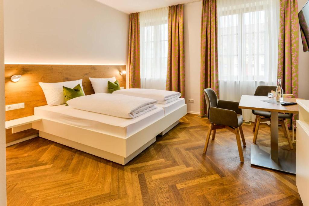 a hotel room with a bed and a desk at Bett´n Glück - Übernachtung & Frühstück in Zusmarshausen