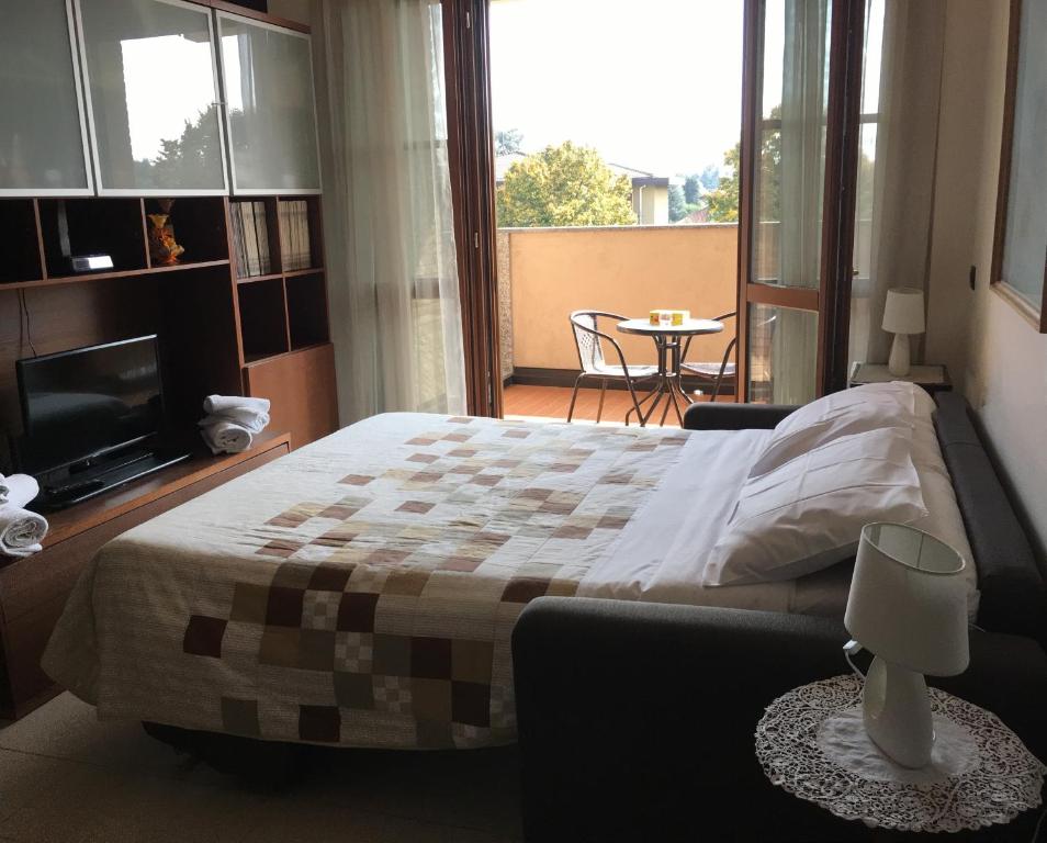 メレニャーノにあるSuite Carpianoのベッドルーム1室(ベッド1台付)、バルコニー(テーブル付)