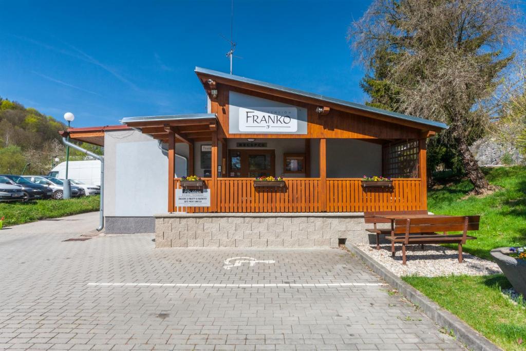 un edificio con un banco en un aparcamiento en Pension Franko, en Český Krumlov