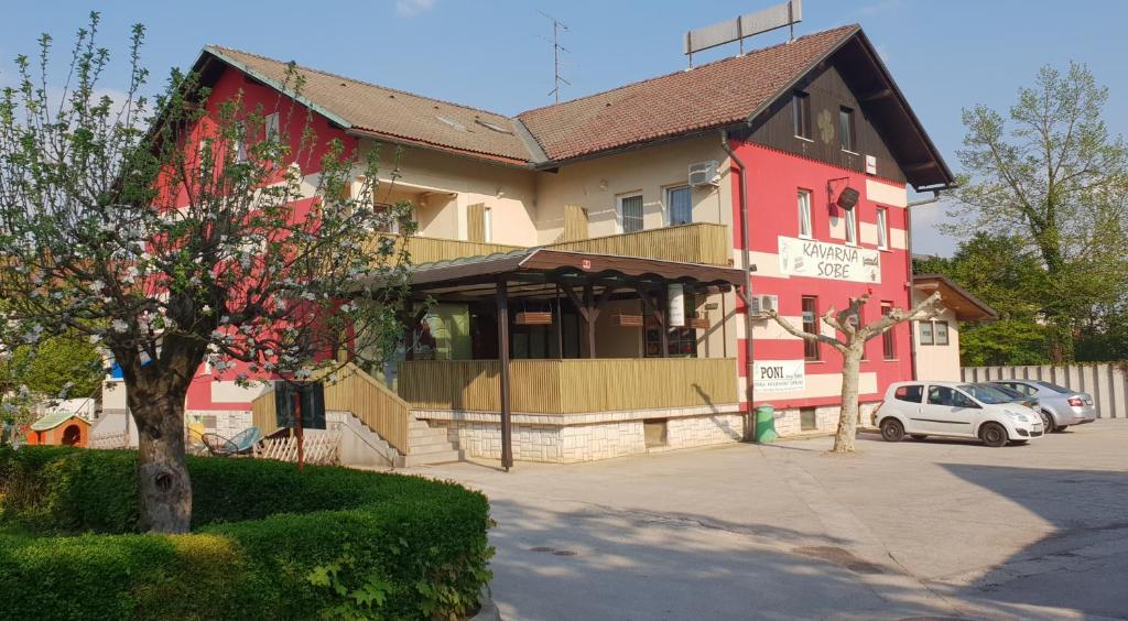 ein Gebäude mit einem roten und gelben Gebäude in der Unterkunft PONI NAKLO - Sobe Marinšek in Naklo