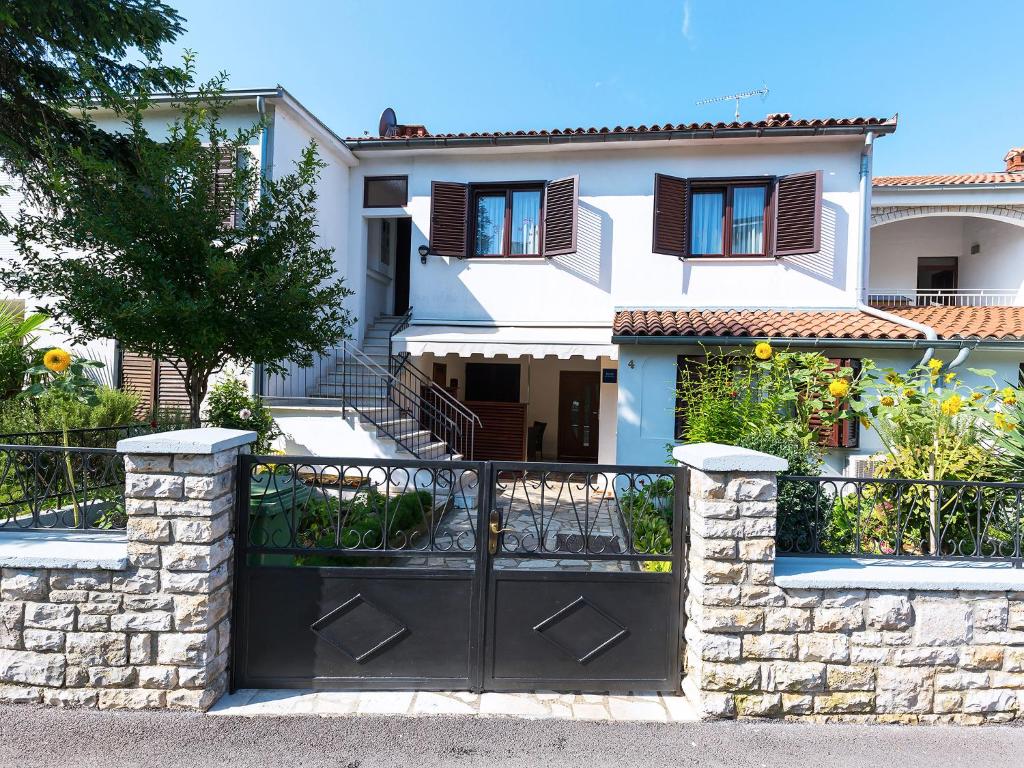 a house with a black gate in front of it at Apartments Nives in Poreč