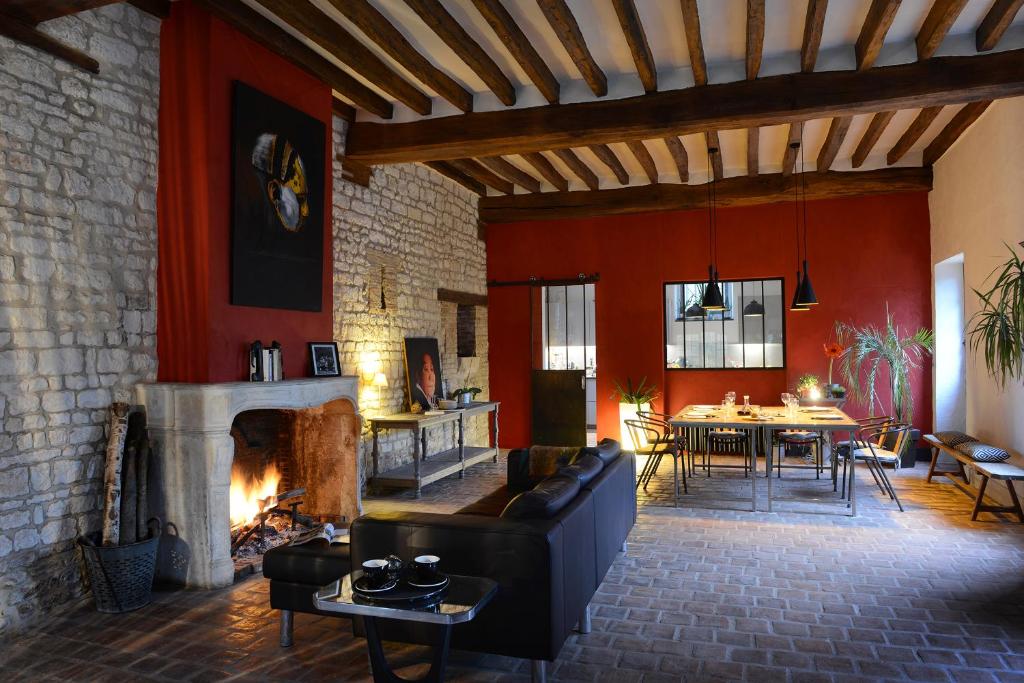 a living room with a couch and a fireplace at Domaine de l'Ocrerie in Pourrain