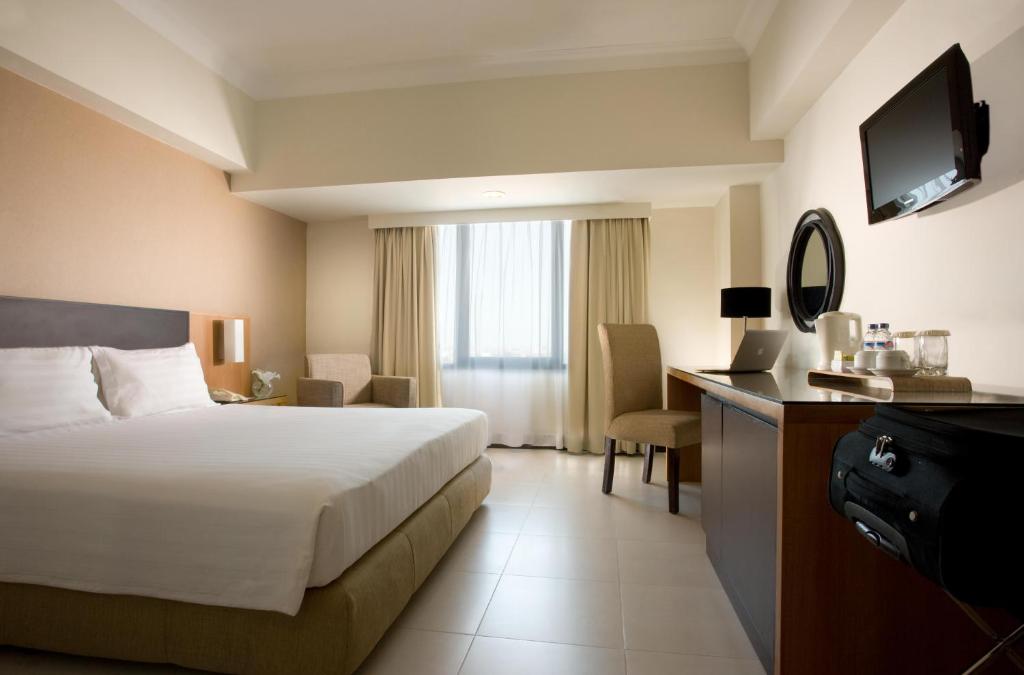Postel nebo postele na pokoji v ubytování Hotel Santika Pandegiling - Surabaya