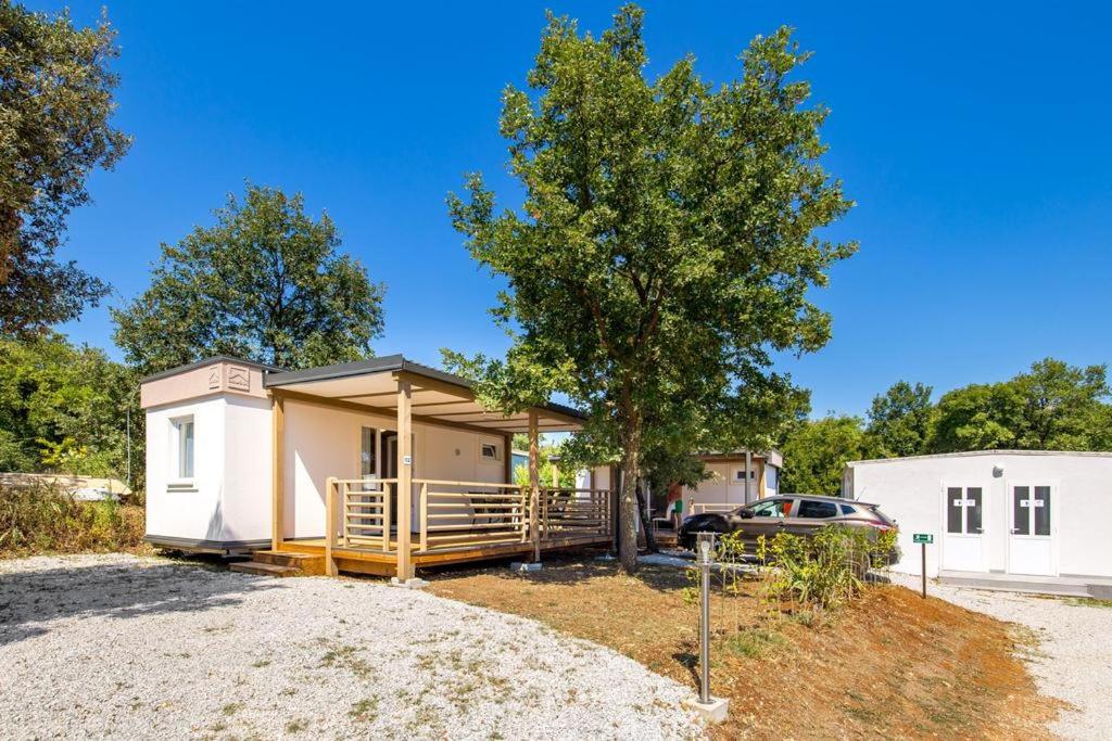 a house with a car parked in front of it at Mini camping FUNTANA in Poreč