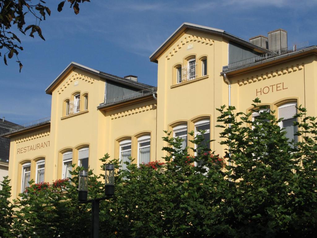 a hotel building with trees in front of it at Ducky’s Restaurant | Events | Hotel in Bad Nauheim