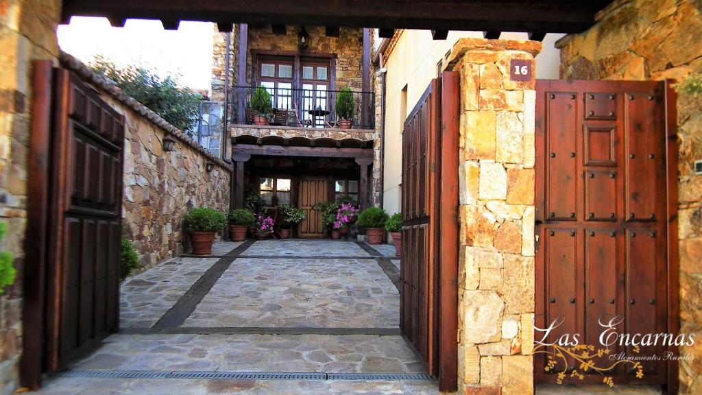 Une allée avec une entrée pour un bâtiment avec des portes dans l'établissement Las Encarnas, à Braojos de la Sierra