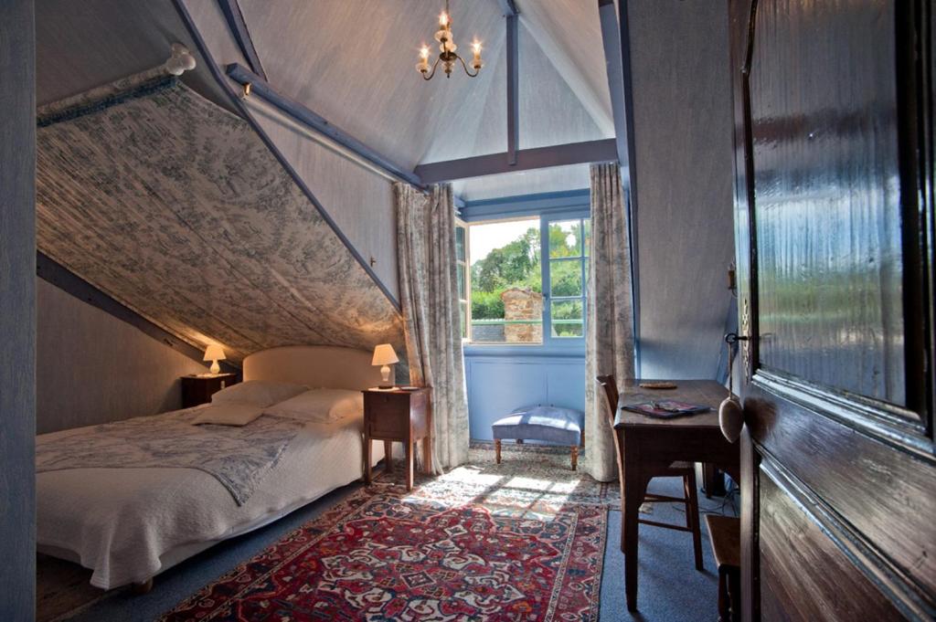 a bedroom with a canopy bed and a window at Chambres d'hôtes Logis Du Jerzual in Dinan