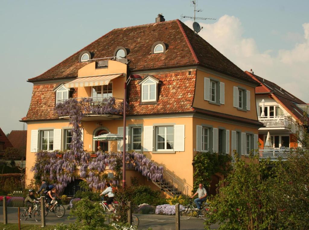 a house with people riding bikes in front of it at Villa Linke am Bodensee in Nonnenhorn