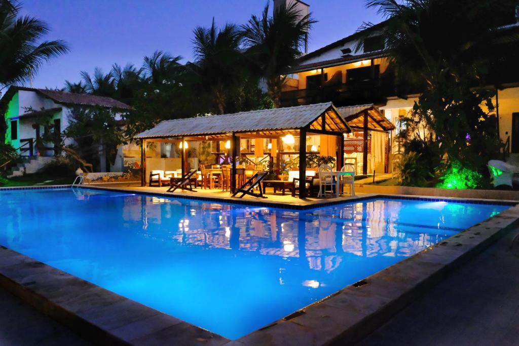 a swimming pool in front of a house at night at Hotel e Pousada La Dolce Vita in Canoa Quebrada