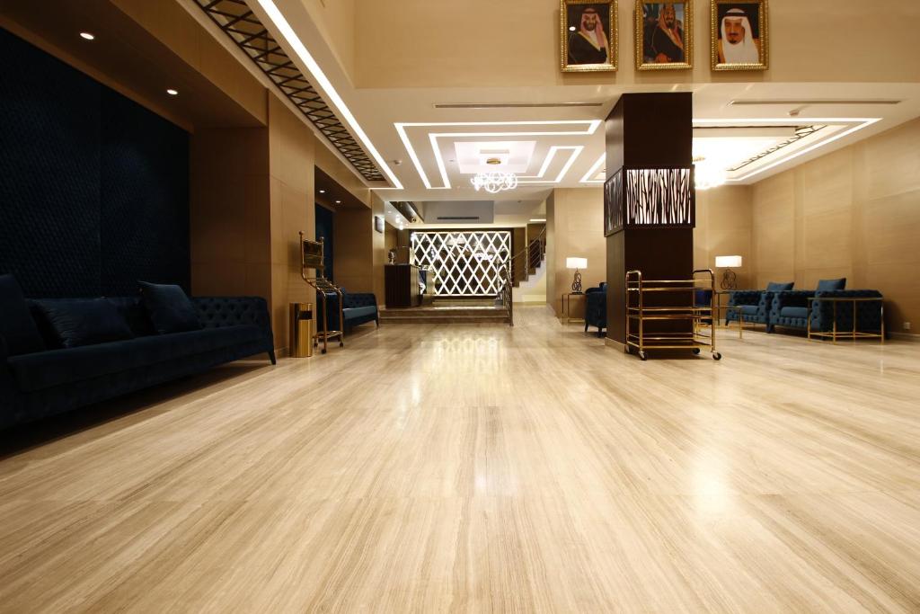 a large room with a wooden floor and blue couches at Best Level Hotel in Jeddah