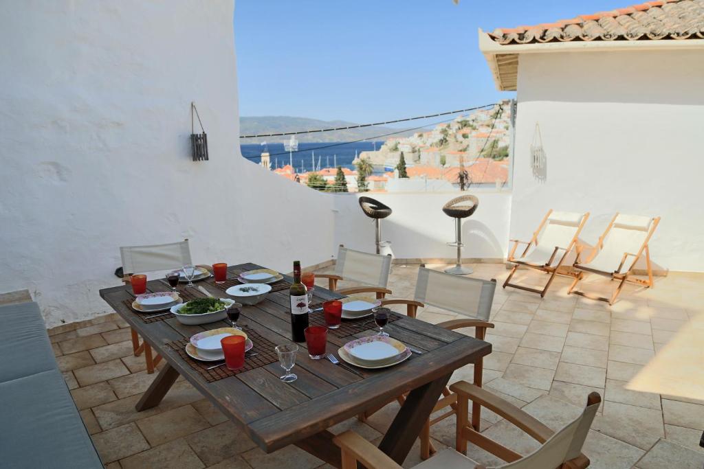 a wooden table with plates of food on a patio at Hydra Optima in Hydra