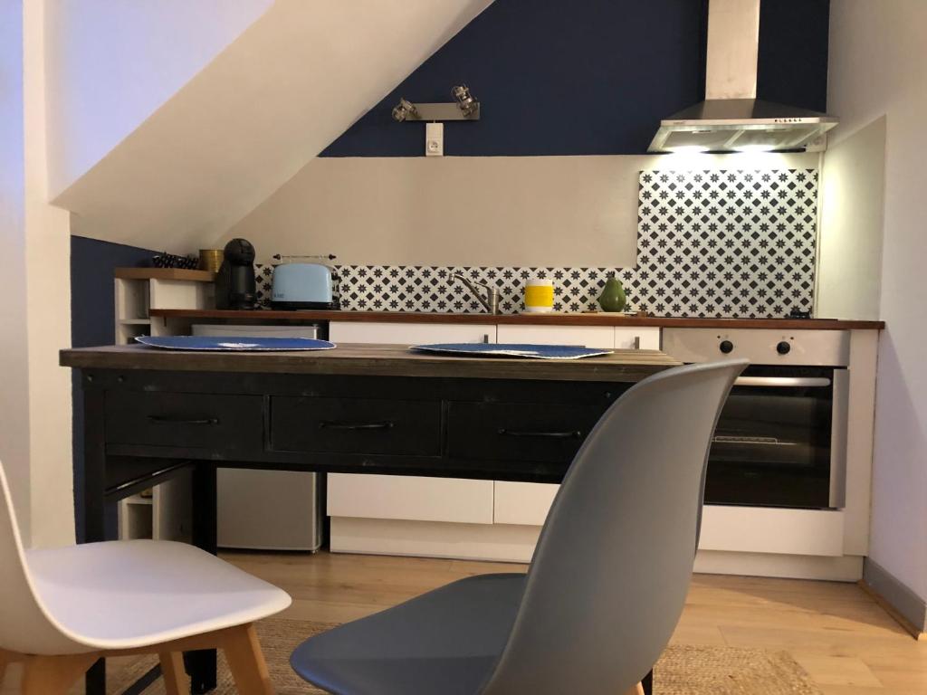 a kitchen with a sink and two white chairs at ★ Studio ★ Brive Centre ★ in Brive-la-Gaillarde