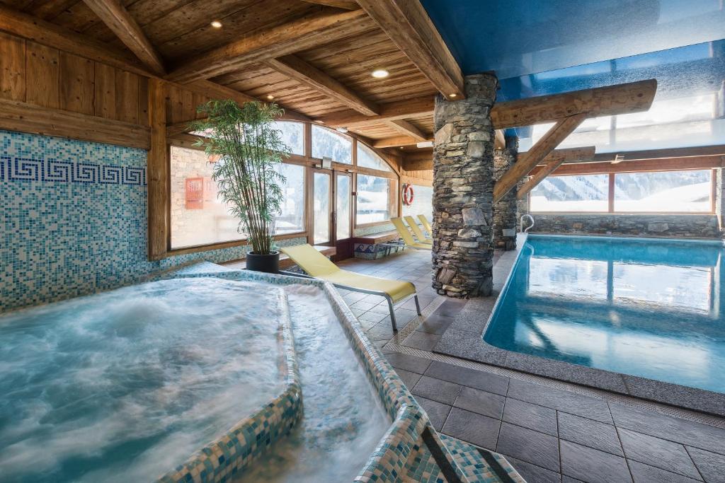 uma banheira de hidromassagem num quarto com em CGH Résidences & Spas Les Fermes de Ste Foy em Sainte-Foy-Tarentaise