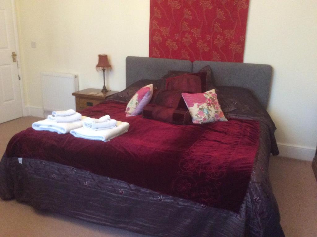1 dormitorio con 1 cama con 2 toallas en Cheltenham Lawn and Pittvile Gallery en Cheltenham