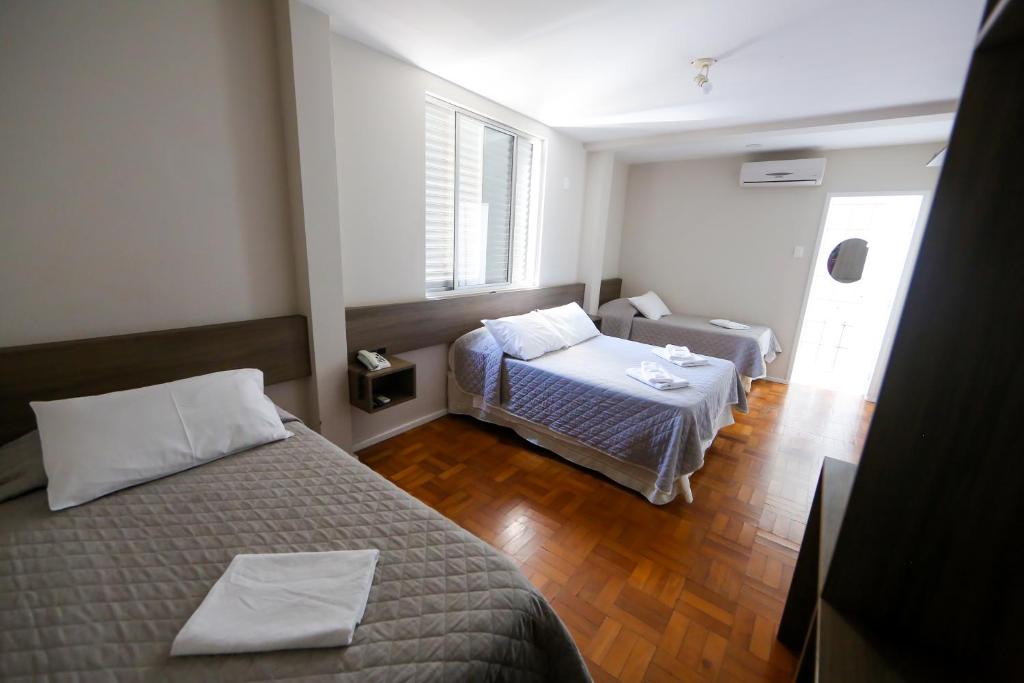 mały pokój z 2 łóżkami i kanapą w obiekcie Hotel Mos São José w mieście São José