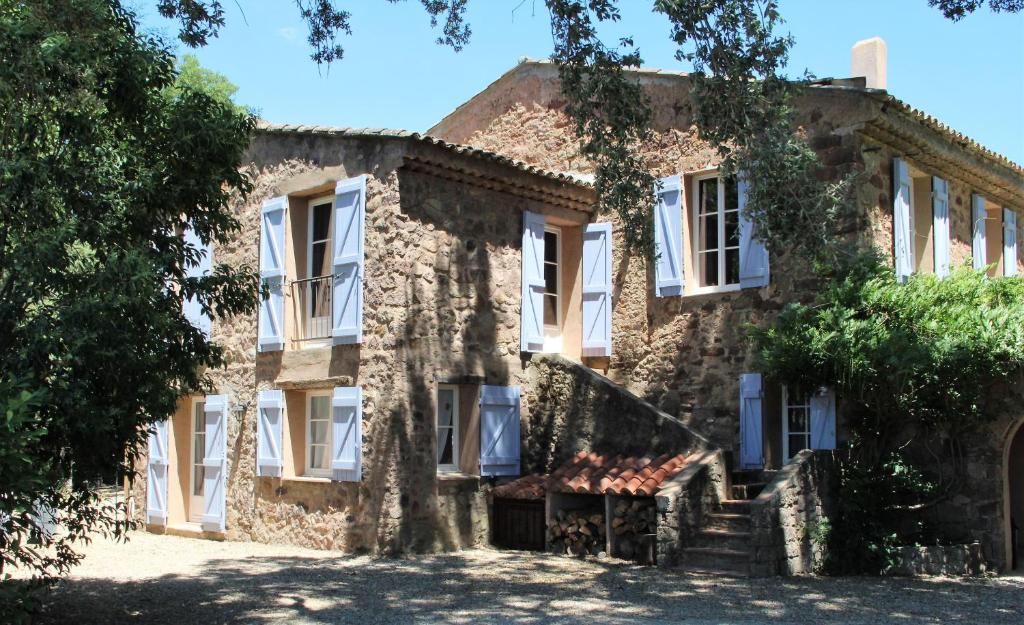 Casa de piedra antigua con ventanas blancas en Chateau des Bertrands en Le Cannet-des-Maures