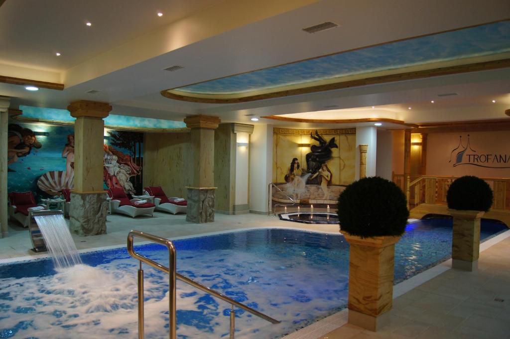 a large swimming pool with a large mirror at Trofana Wellness & SPA in Międzyzdroje