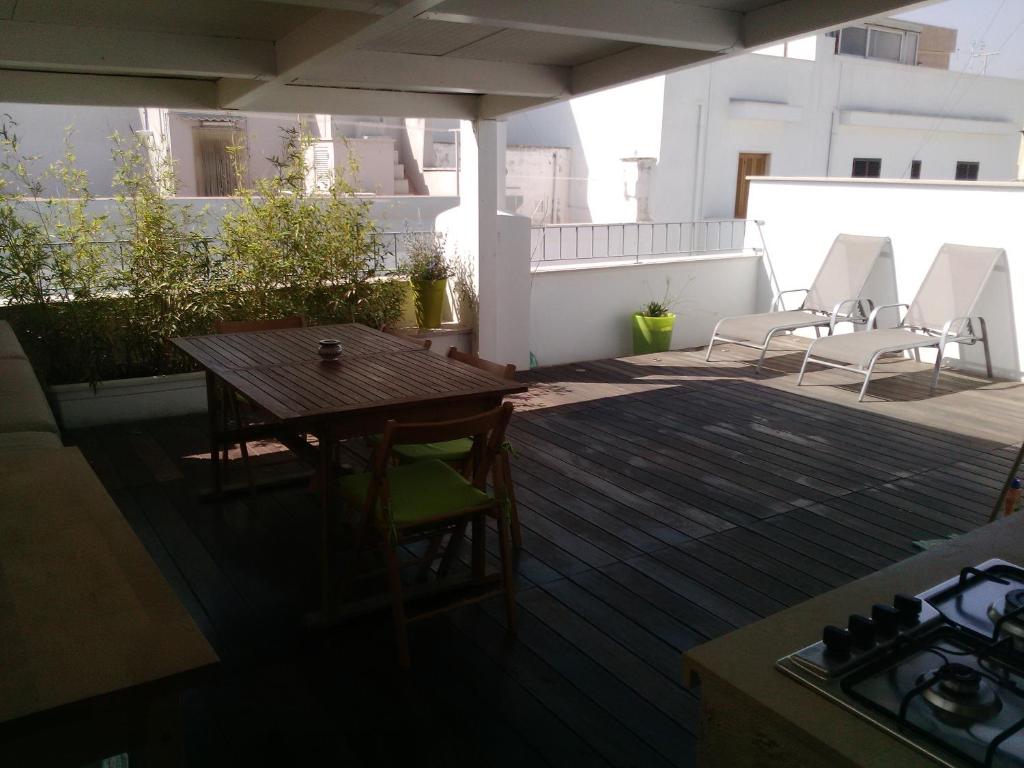 un patio con tavolo e sedie sul balcone. di Dimora Dioniso a Polignano a Mare