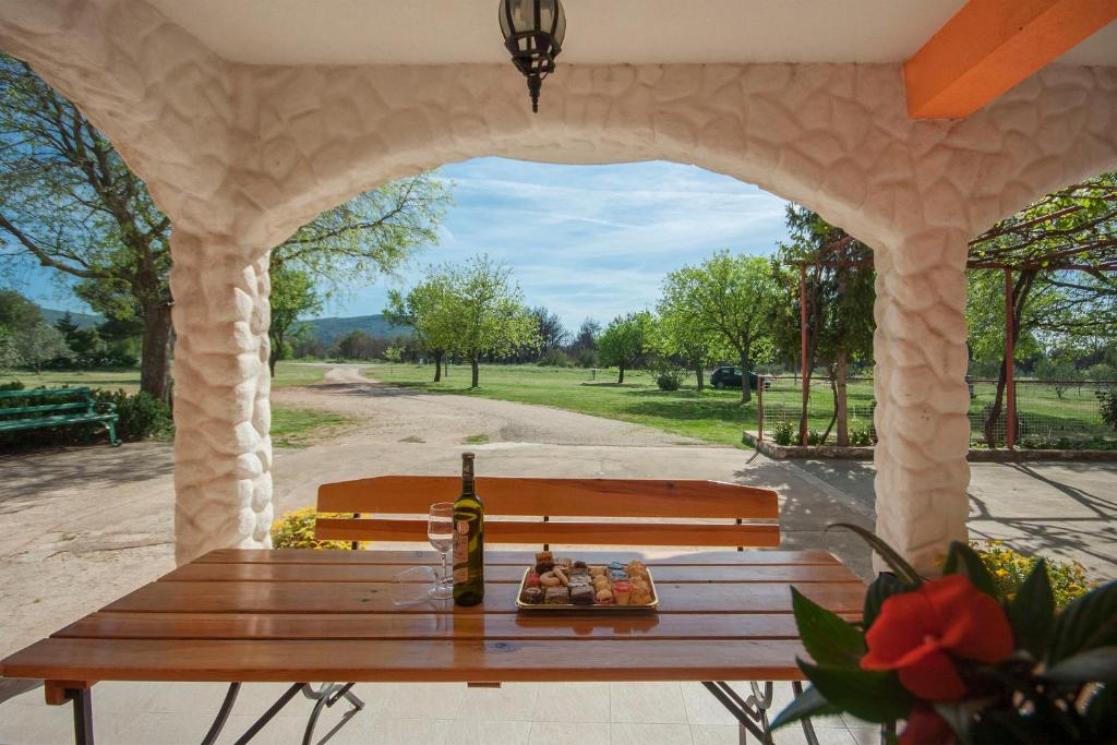 a picnic table with a bottle of wine on a patio at Rooms Katarina in Lozovac