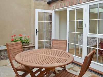 a wooden table and chairs on a patio at The Old Carriage House in York