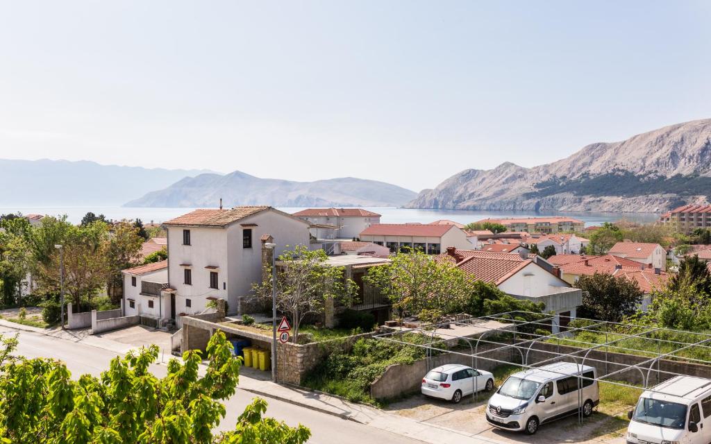 une ville avec des voitures garées dans un parking dans l'établissement King's Apartment, à Baška