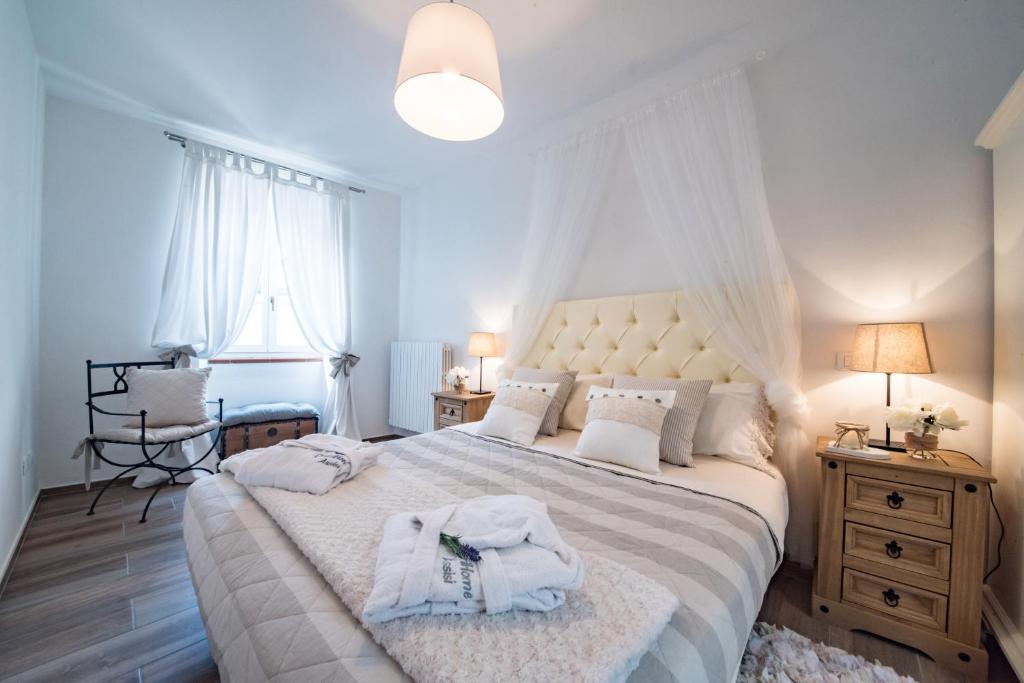 a bedroom with a large bed with towels on it at ChèriHomeAssisi Apartment in Assisi