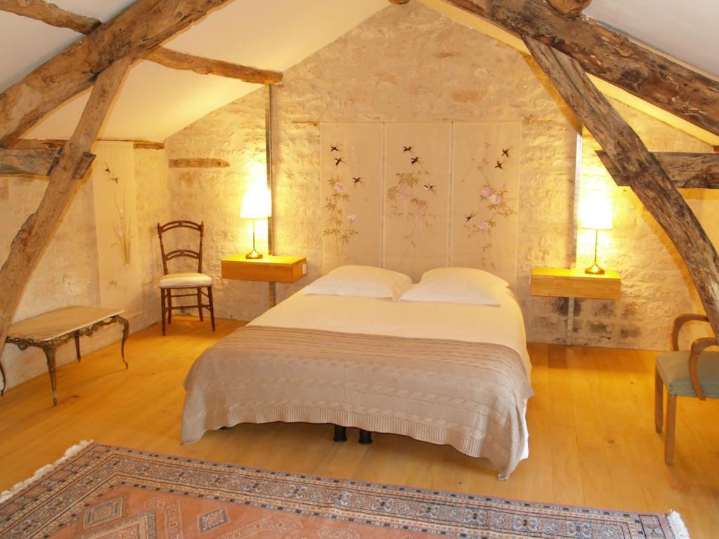 een slaapkamer met een bed en 2 lampen en een stoel bij La Vayssade - Gîte de Charme - 6 pers - Piscine Jacuzzi & Truffes in Lalbenque