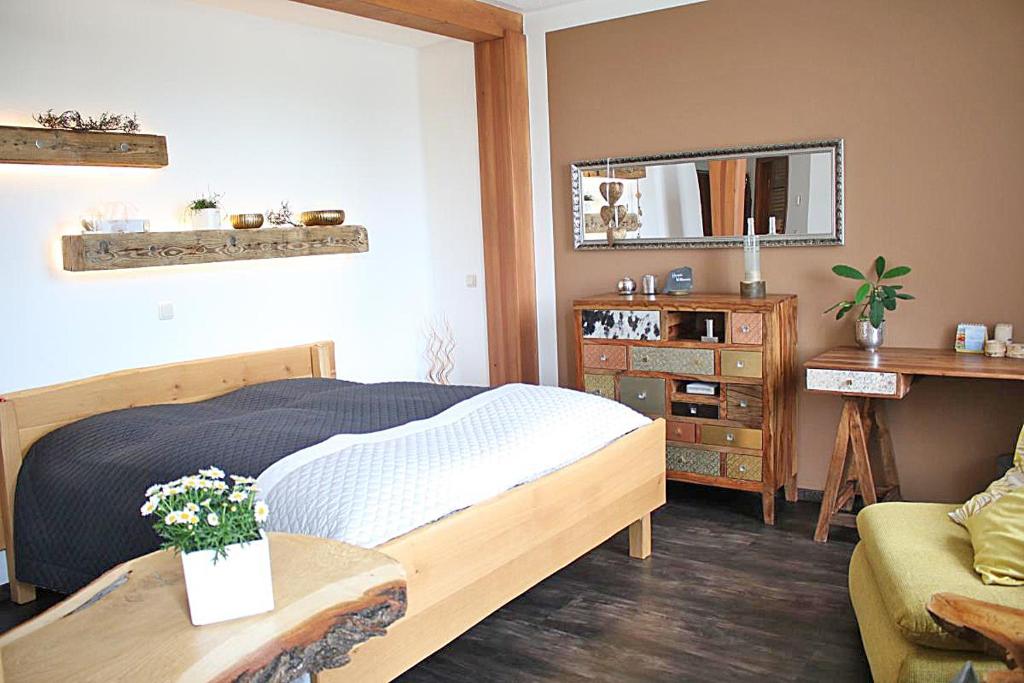 Schlafzimmer mit einem Bett, einem Tisch und einem Spiegel in der Unterkunft Ehem. Sächsisch-Bayrischer Hof in Pöhl