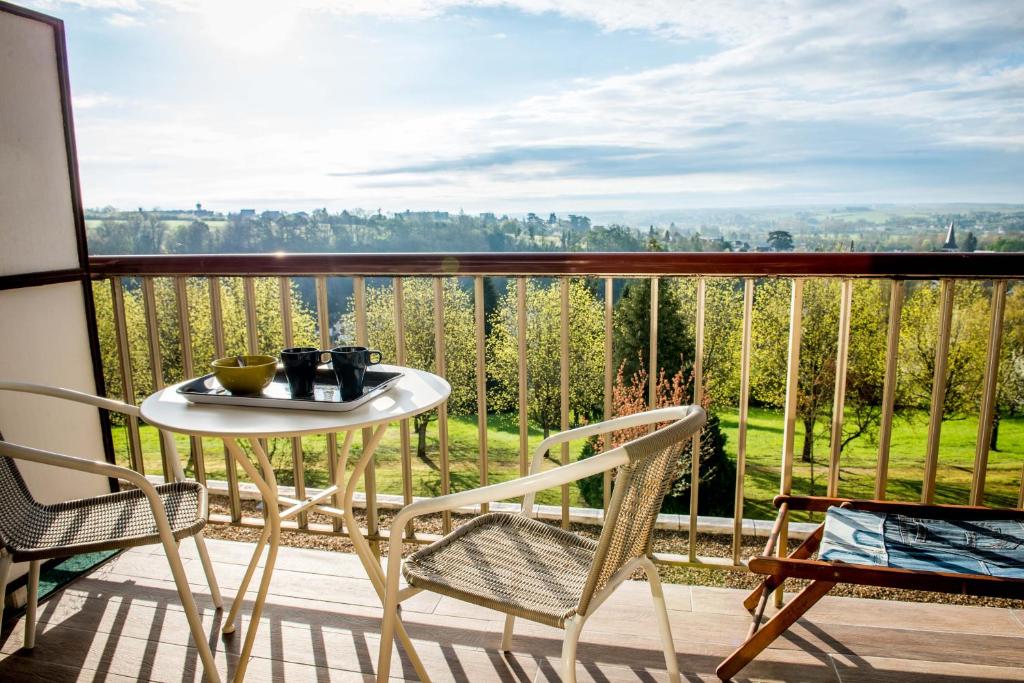 uma mesa e cadeiras numa varanda com vista em Studio de charme au coeur d'un Parc em Montrichard