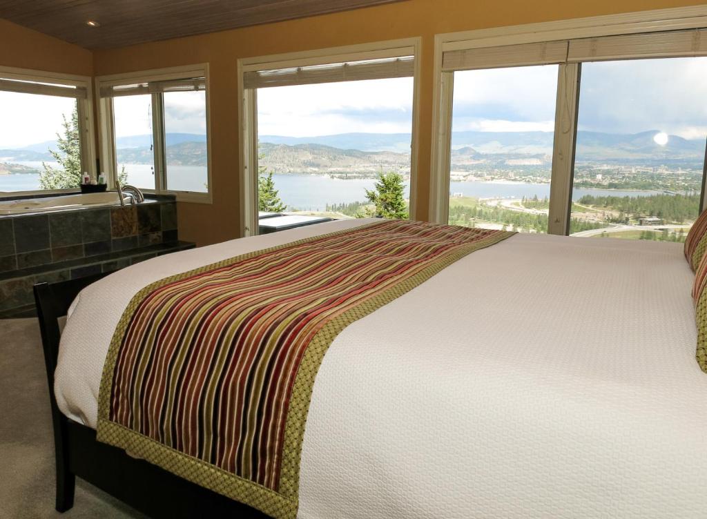 Dormitorio con cama y vistas al agua en A View of the Lake B & B en West Kelowna