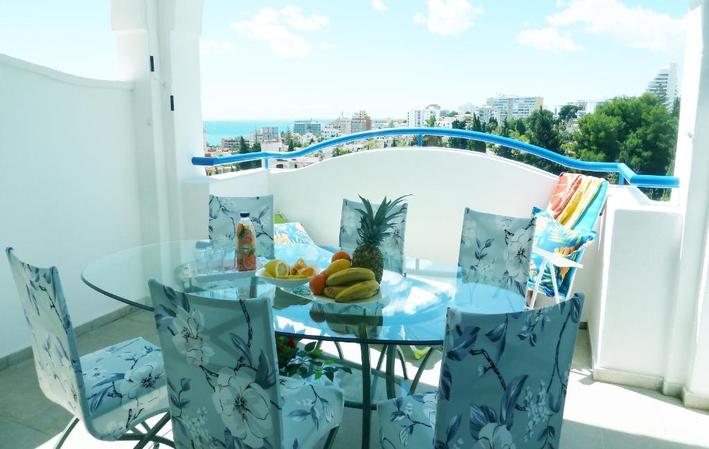 un tavolo in vetro con un piatto di frutta sul balcone di Luxury residence near Puerto Marina a Benalmádena