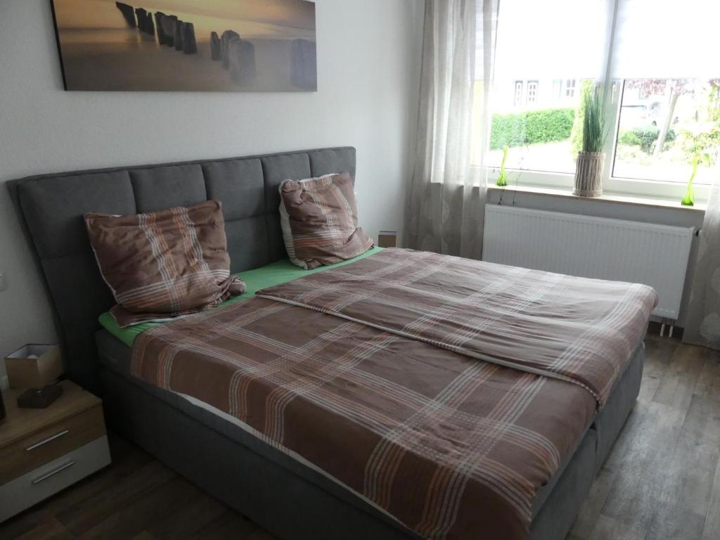 een bed met kussens in een kamer met een raam bij Ferienwohnung Anke - Apartment 5a in Heinsberg