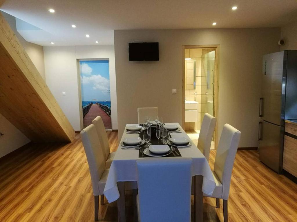 uma sala de jantar com uma mesa branca e cadeiras em Room4U Apartment em Balatonszemes