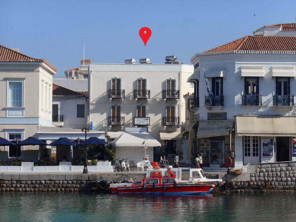 斯佩察島的住宿－Alexandris Hotel，船在水中,在建筑物前
